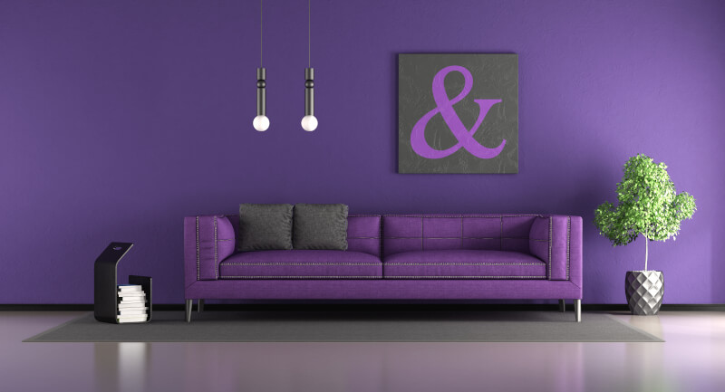 ściany i sofa w kolorze purpurowym z czarnymi i szarymi akcentami