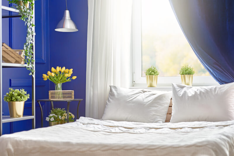 Ściany i zasłony w sypialni w kolorze navy blue