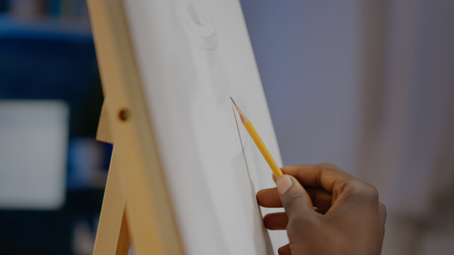 Osoba szkicująca ołówkiem na białym płótnie malarskim