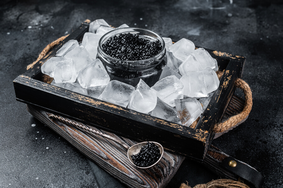 Czarny kawior z lodem podany na drewnianej tacy
