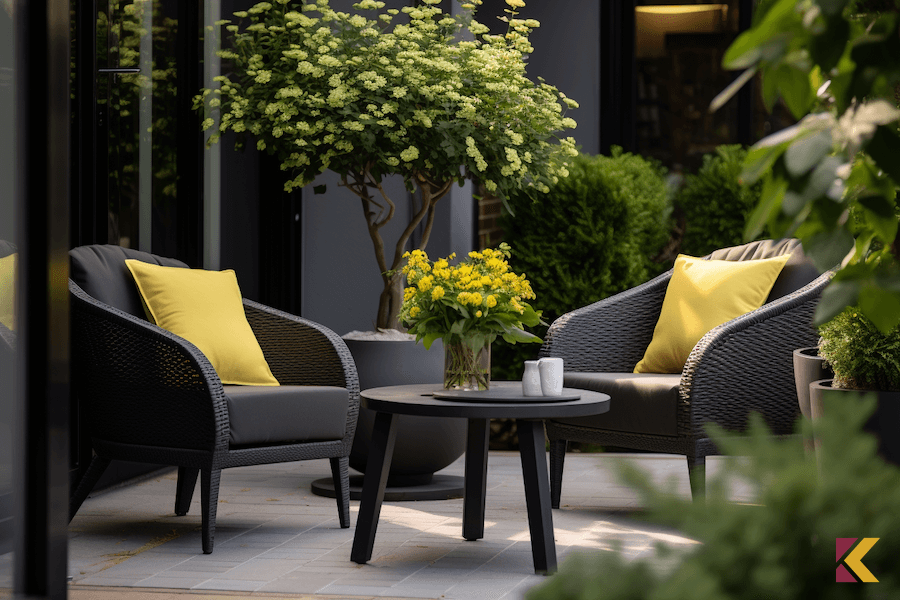 Antracytowe fotele i stolik ogrodowy przed domem, kanarkowe poduszki na fotelach