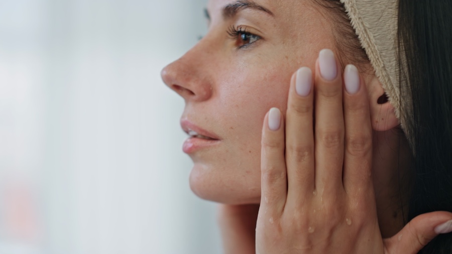 Kobieta wklepująca kosmetyk w twarz