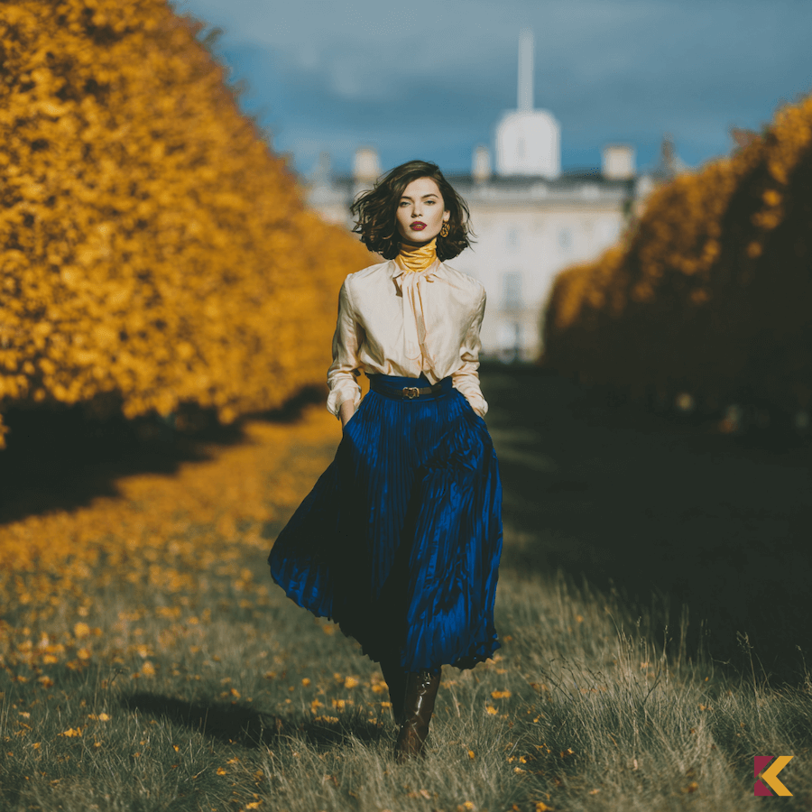 Rozkloszowana szafirowa spódnica w połączeniu z bufiastą koszulą w odcieniu ivory